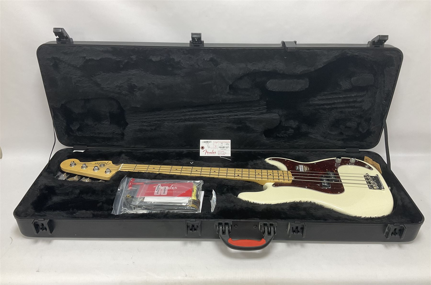 Fender Precision Bass guitar, in Olympic White finish with tortoiseshell effect scratchboard, serial no US15103092, in black Fender hard case with Fender strap and warranty card, guitar L116cm