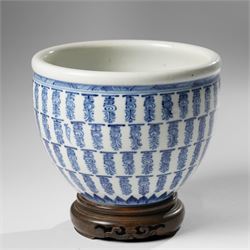 Chinese fish bowl, painted profusely with repeating symbols in blue, on hardwood stand, un...