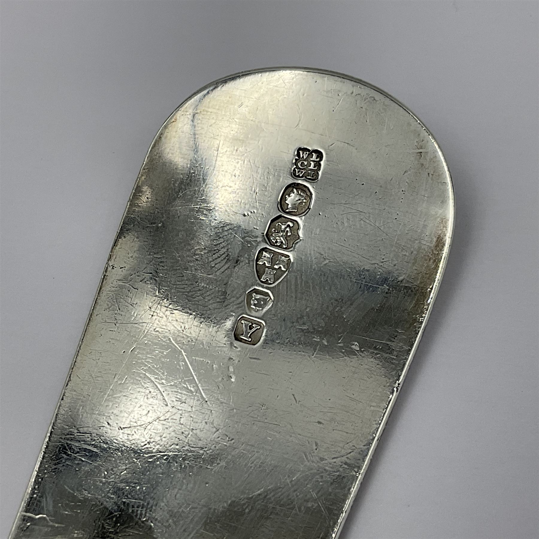 Victorian Newcastle silver Fiddle Shell pattern serving spoon, the terminal engraved with crest of a fist holding an arrow aloft, hallmarked Lister & Sons, Newcastle 1862, L31cm