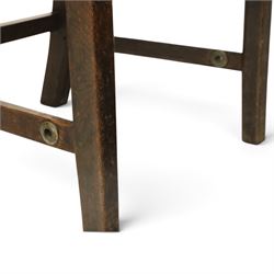 DD CL - Early 20th century oak open armchair, rectangular back with scrolled uprights, brown upholstered back and seat with brass stud edging, shaped open arms on turned supports, square legs united by stretchers