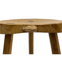 'Rabbitman' oak milking stool, dished kidney shaped top with three tapered octagonal supports, carved with rabbit signature to rim, by Peter Heap of Wetwang