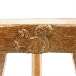 Squirrelman - rustic oak milking stool, adzed shaped top with exposed peg construction, on three tapering supports, with large carved squirrel signature, by Wilf Hutchinson, Husthwaite