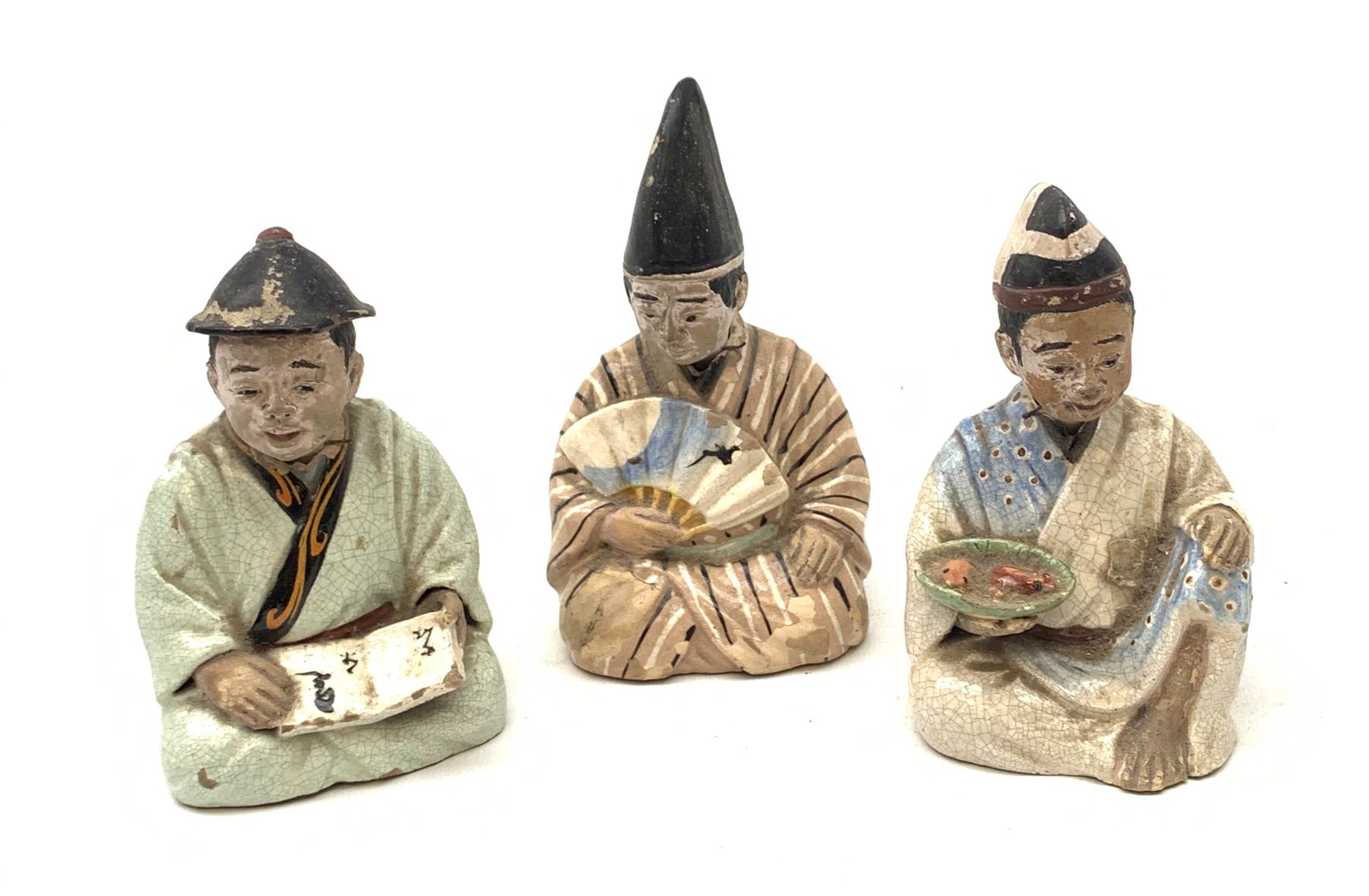 Three Japanese earthenware nodding head figures, each modelled as a seated male, tallest H13.5cm.  
