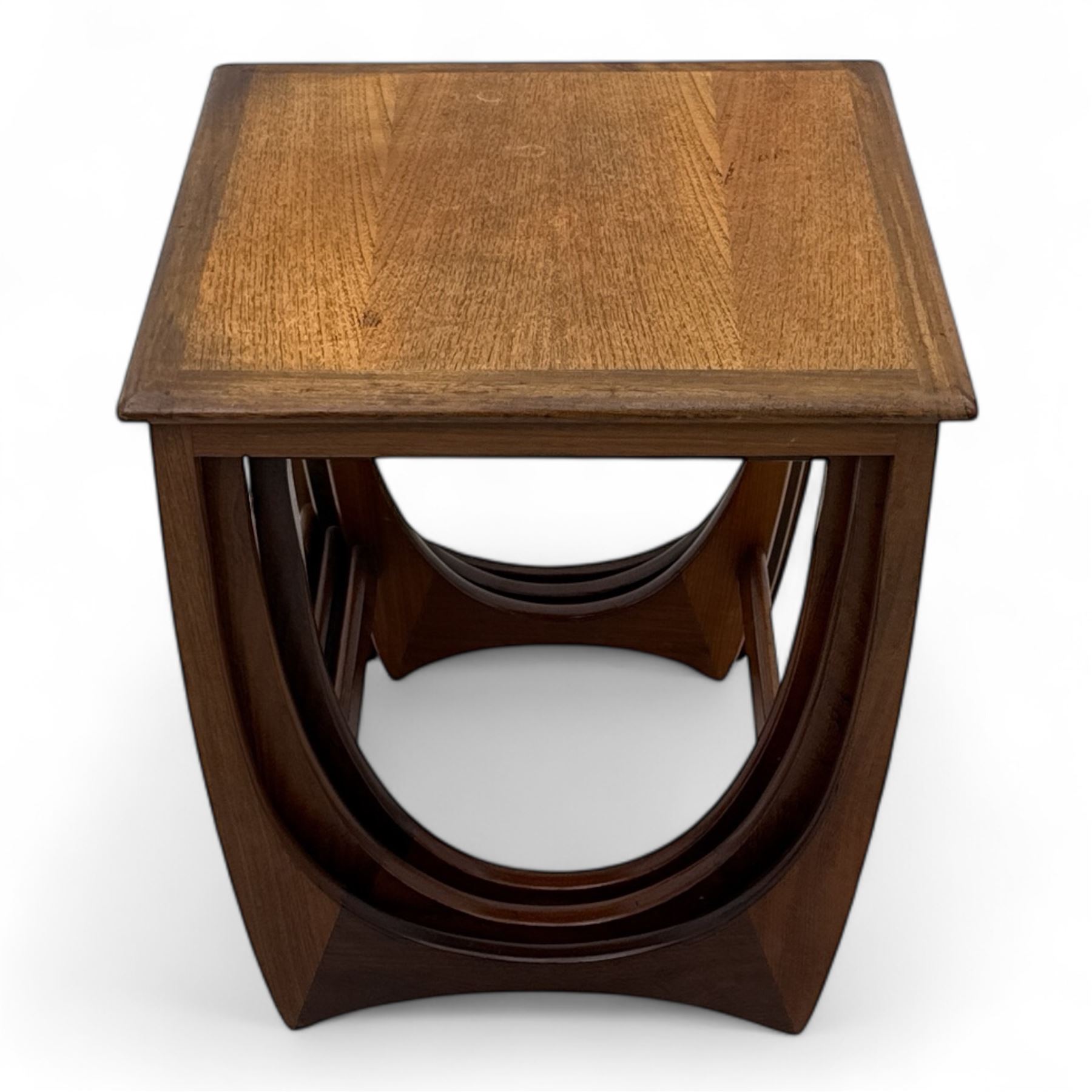 G-Plan - 'Astro' mid-century nest of three teak occasional tables, each with a square top with outer banding, on U-shaped end supports united by a stretcher