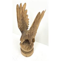 A carved carved wooden figure, modelled as an eagle upon a sphere and circular base, overall H105.5cm. 