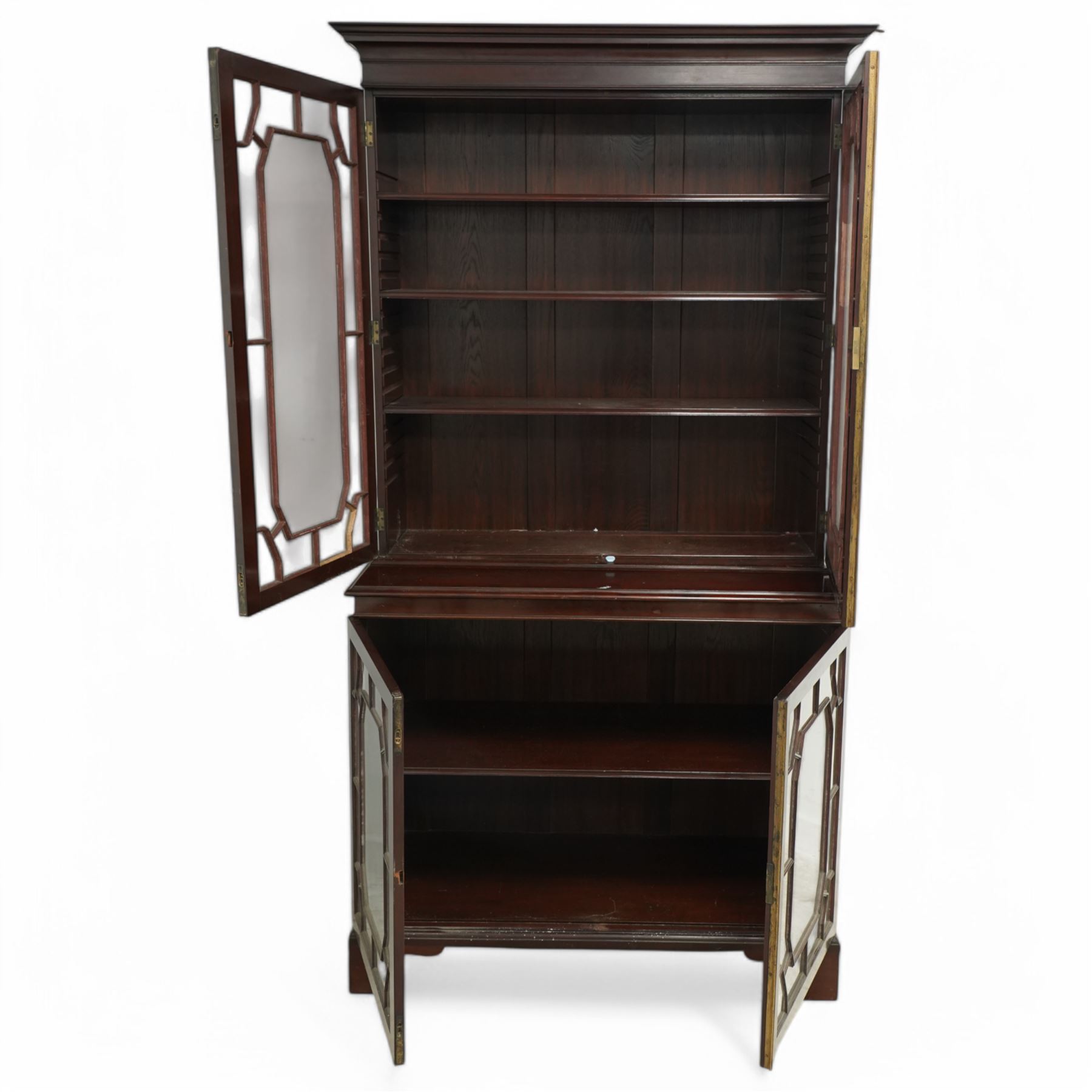 Early 20th century Chippendale design mahogany bookcase, projecting moulded cornice over four astragal glazed doors, the interior fitted with adjustable shelves, on bracket feet 