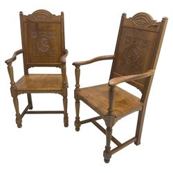 Pair of 17th century design oak open armchairs, the shaped cresting rail carved with oval leaf motif, panelled back carved with mask and foliage, moulded plank seat on turned supports united by H-shaped stretchers 