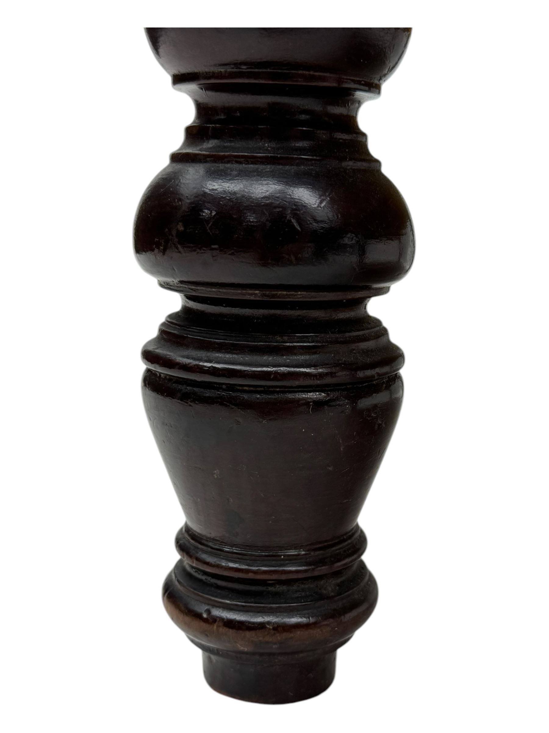 Late Victorian carved mahogany open armchair, the shaped back with fluted upholstered panel and padded arms above pierced scroll carved side supports, over a broad upholstered seat, on turned front supports