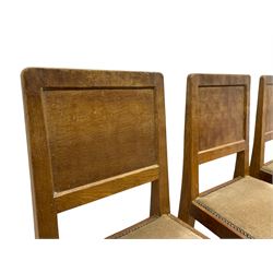 'Eagleman' set four oak dining chairs, adzed panelled backs, upholstered seats with stud work band, the side rails relief carved with inset eagle signature, shaped octagonal supports joined by stretchers, by Albert Jeffray of Sessay, Thirsk