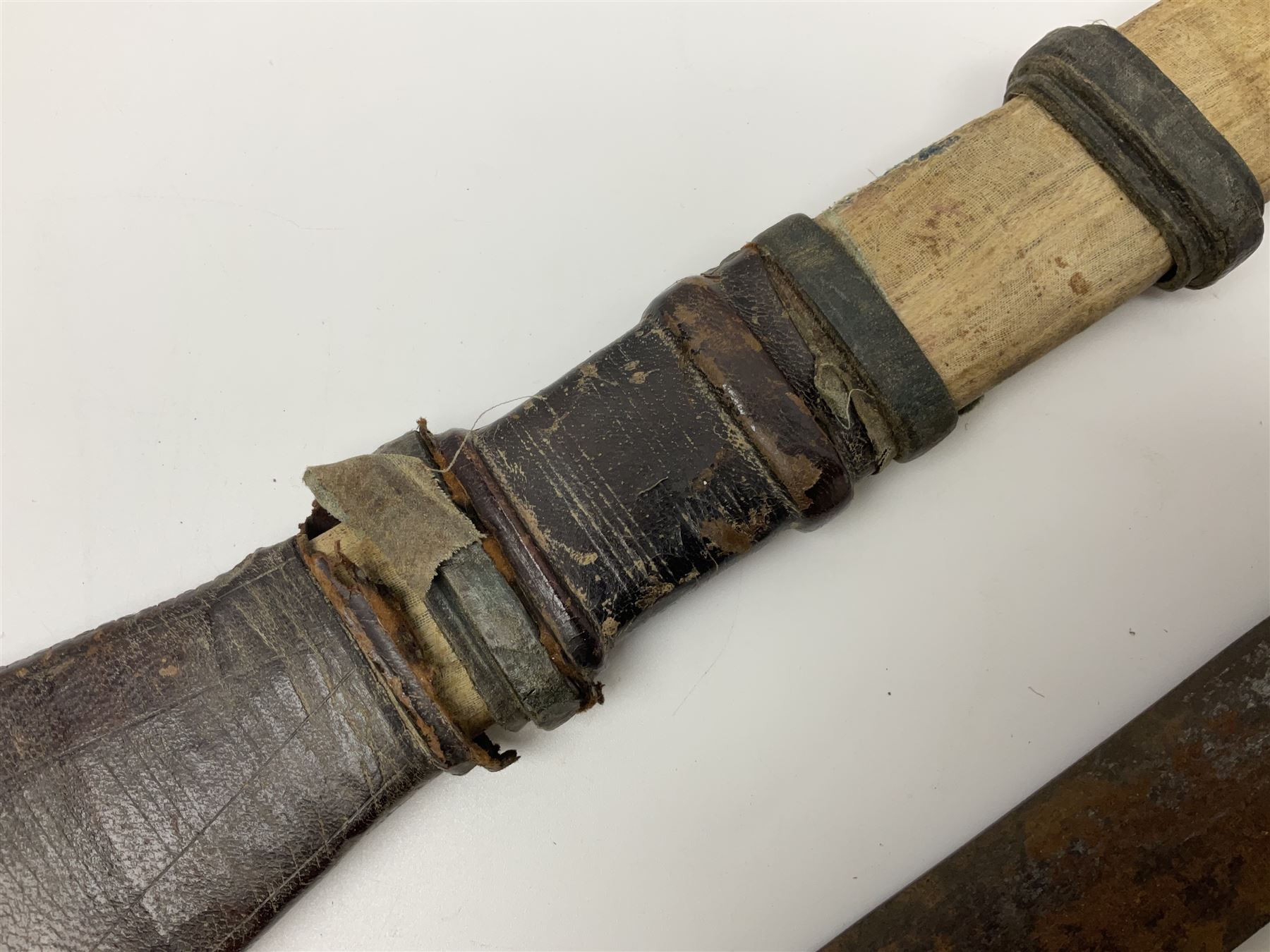 African Mandingo sword, the 75cm triple fullered blade with leather covered grip and brass pommel, in part leather covered scabbard with leaf shaped point L98cm overall