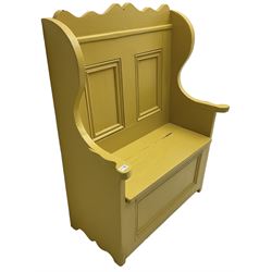 Early 20th century painted pine settle hall bench, shaped cresting rail over panelled back, hinged box seat, in mustard yellow finish