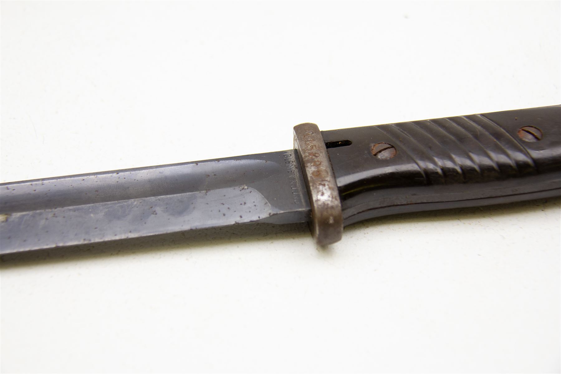 WWII German K98 bayonet by Clemen & Jung, the 24.5cm fullered blade marked 8647 h, with Bakelite grip and bluing to metal blade; in steel scabbard with corresponding numbers and leather frog, L42cm overall