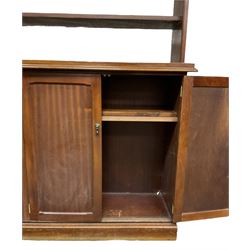 20th century mahogany bookcase on cupboard, projecting cornice over three shelves, the lower section enclosed by two double panelled cupboards, on skirted base