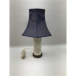 Blanc de Chine style table lamp with pierced foliate decoration, on a hardwood base, with a blue fabric shade, H36cm, together with black lacquered Chinese headrest, converted into a lamp, on a hardwood base, with yellow oval shade with tassels H50cm. .  