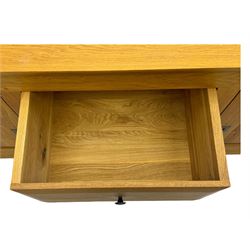 Contemporary light oak sideboard, chamfered rectangular top over two central bevel-edged drawers, flanked by two recessed panelled cupboards enclosing shelving, on square stile supports