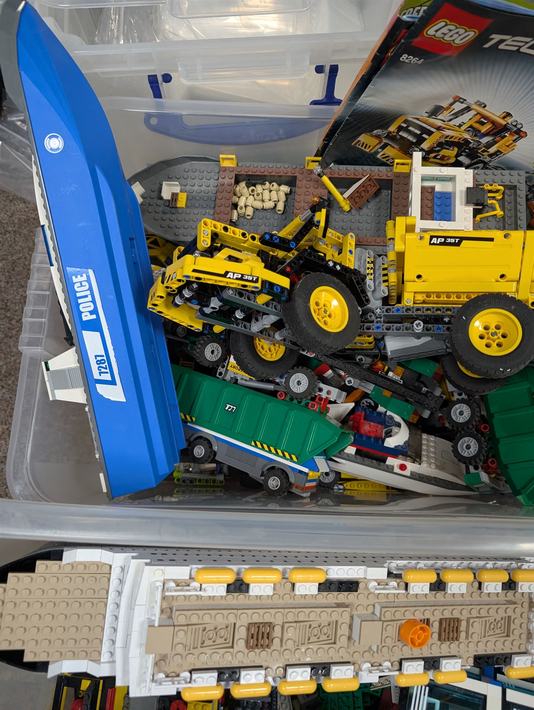 Two boxes of partially built Lego vehicles, including Lego Technics Dumper Truck no. 8264, Titanic, container ships, police boat, smaller police vehicles, etc