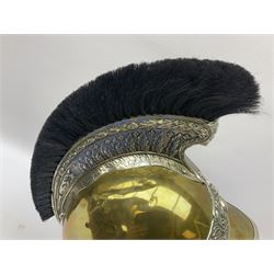 Early 20th century French mounted gendarme's helmet, brass with nickel-silver mountings, broad band embossed with fused grenade, high comb with the face of the gorgon Medusa at the peak and with a black horse hair crest, plume socket at the left, leather-backed nickel-silver chin scales with lion mask mounts.