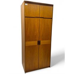 William Lawrence - mid-20th century teak double wardrobe, upper storage section over twin doors featuring recessed handles and contrasting horizontal panel, enclosing a hanging rail compartment, on plinth base with concealed castors