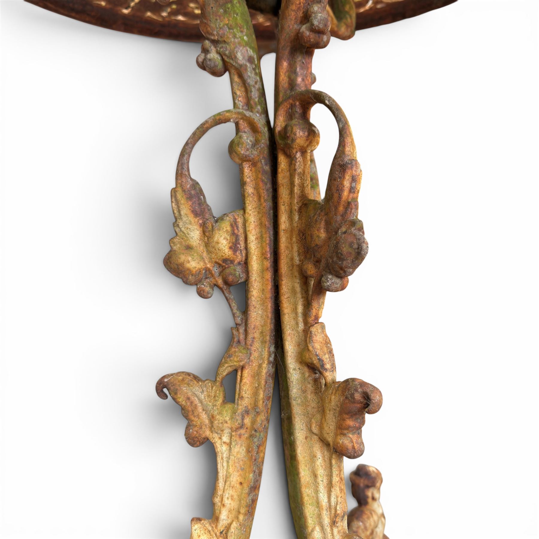 Victorian cast iron garden table, circular pierced top with foliate and scroll decoration, raised on an ornate tripod base with natural weathered paint finish.