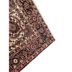 Persian Heriz red ground rug, large medallion decorated with palmettes and Ejder motifs, the border decorated with stylised plant motifs, within floral design guard stripes 