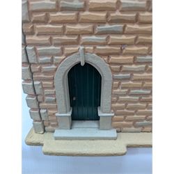 1:24 scale stone effect three-storey cottage dolls house, with green arched door and lattice effect windows, decorated to the interior with wooden floors, wired lighting and fire places, H45cm, W57cm, D26cm