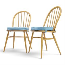 Ercol - pair of 'Windsor' dining chairs, with high hooped back, blue seat cushions with studded, tapered supports  