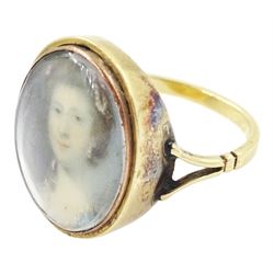 19th century gold portrait ring, set with an oval miniature of a woman wearing a pearl hairpin and earrings on ivory, under a glazed panel, set into a later gold ring with split shoulders. This lot has been registered for sale under Section 10 of the APHA Ivory Act