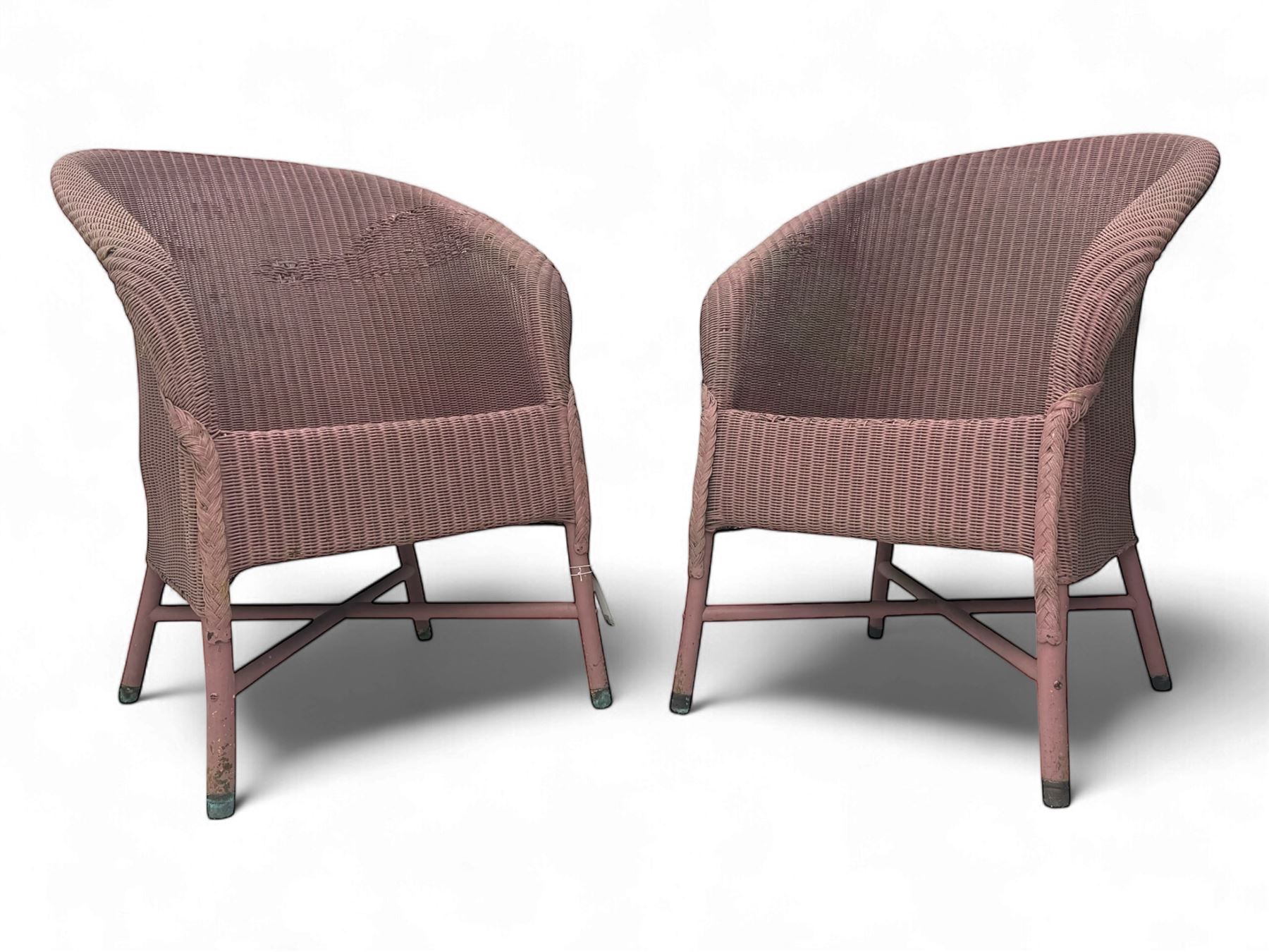 Pair of Lloyd Loom design tub chairs, each with woven wicker construction, curved backrests and painted in a soft pink finish, on cylindrical supports with X-stretchers