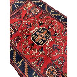 Persian red ground rug, the field decorated with multiple geometric motifs, blue band border with repeating geometric motifs