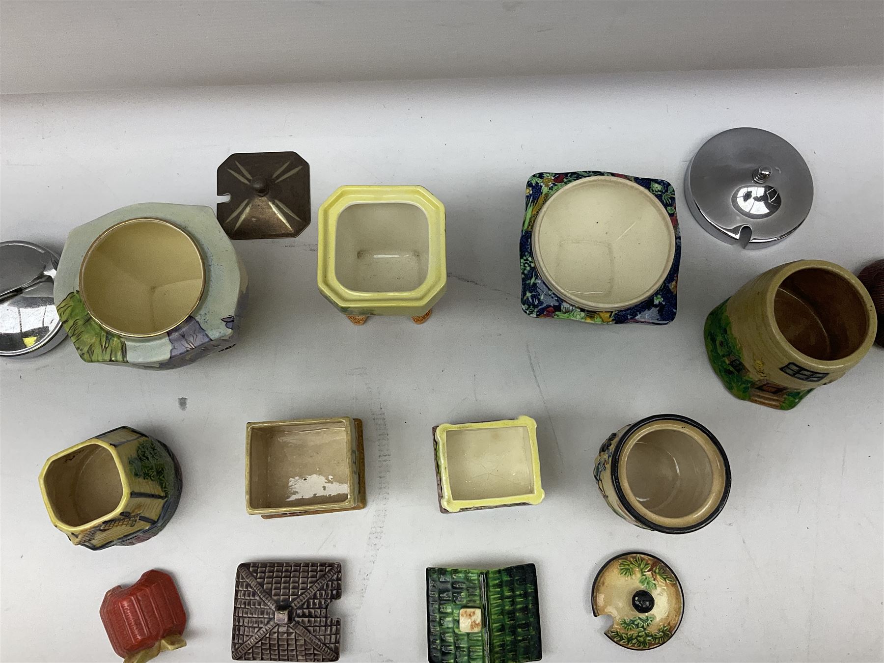Collection of Japanese Maruhon ware novelty preserve pots, to include examples modelled as a windmill and cottages, together with other 1920s and 30s Art Deco style preserve pots, etc