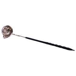 George III silver toddy ladle, the silver circular bowl with side lip, inset with Queen Anne 1708 coin and embossed with flower heads and drapery scrolls, the part silver stem inscribed 'Mother Nunn's Gift Joshua & Mary Nunn', upon an ebonised part twist handle with silver terminal, unmarked but testing as silver, H34.5cm