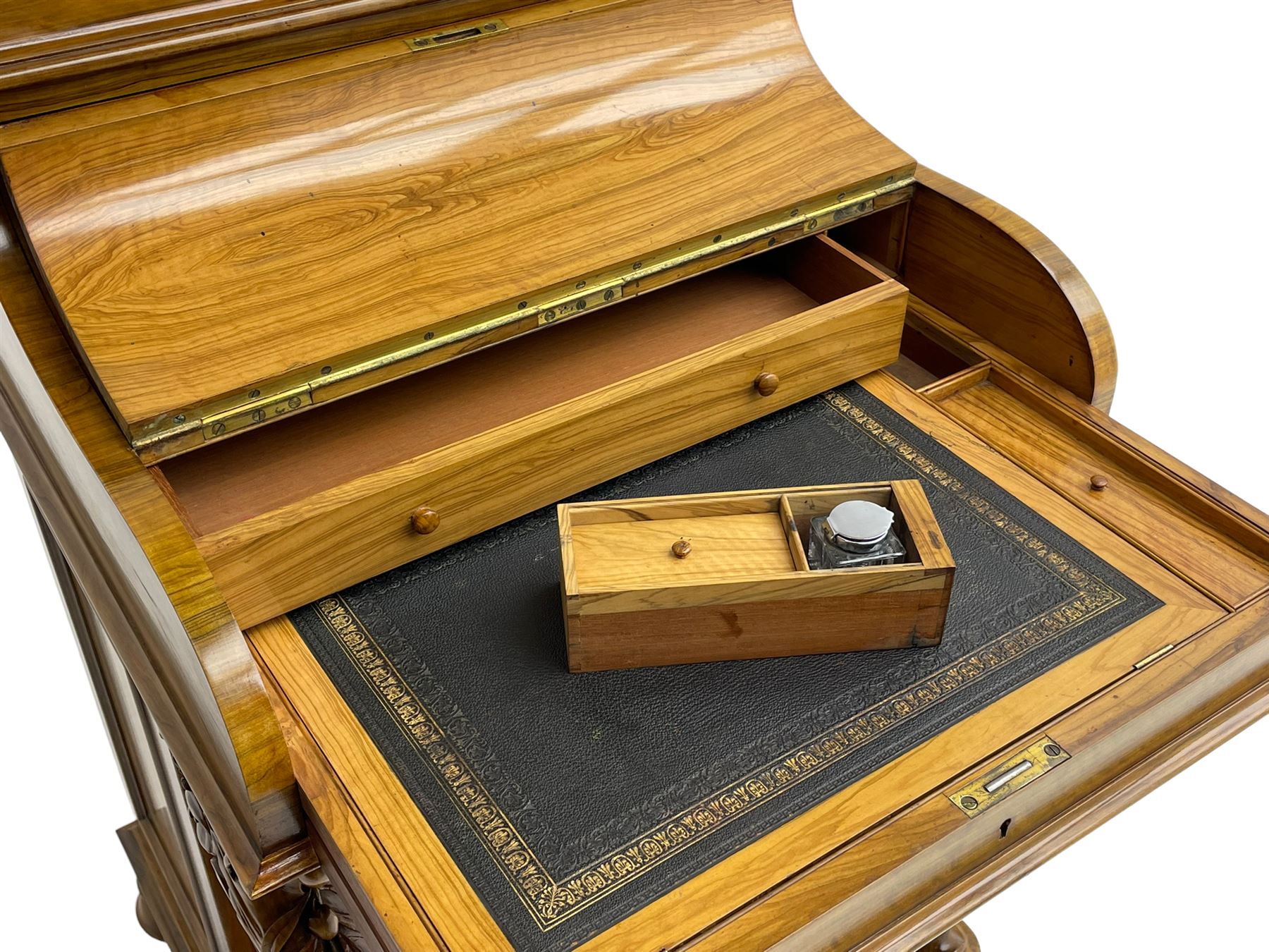Fine and unusual 19th century olivewood piano top davenport, raised shaped back carved with olive branches and olives, the top hinges to reveal lidded and correspondence compartments, the piano lid enclosing sliding top with hinged and adjustable writing surface with leather inset, right-hand panelled door enclosing four drawers, olive branch and scroll carved cabriole front supports on moulded and shaped platform, turned cup feet with recessed castors 