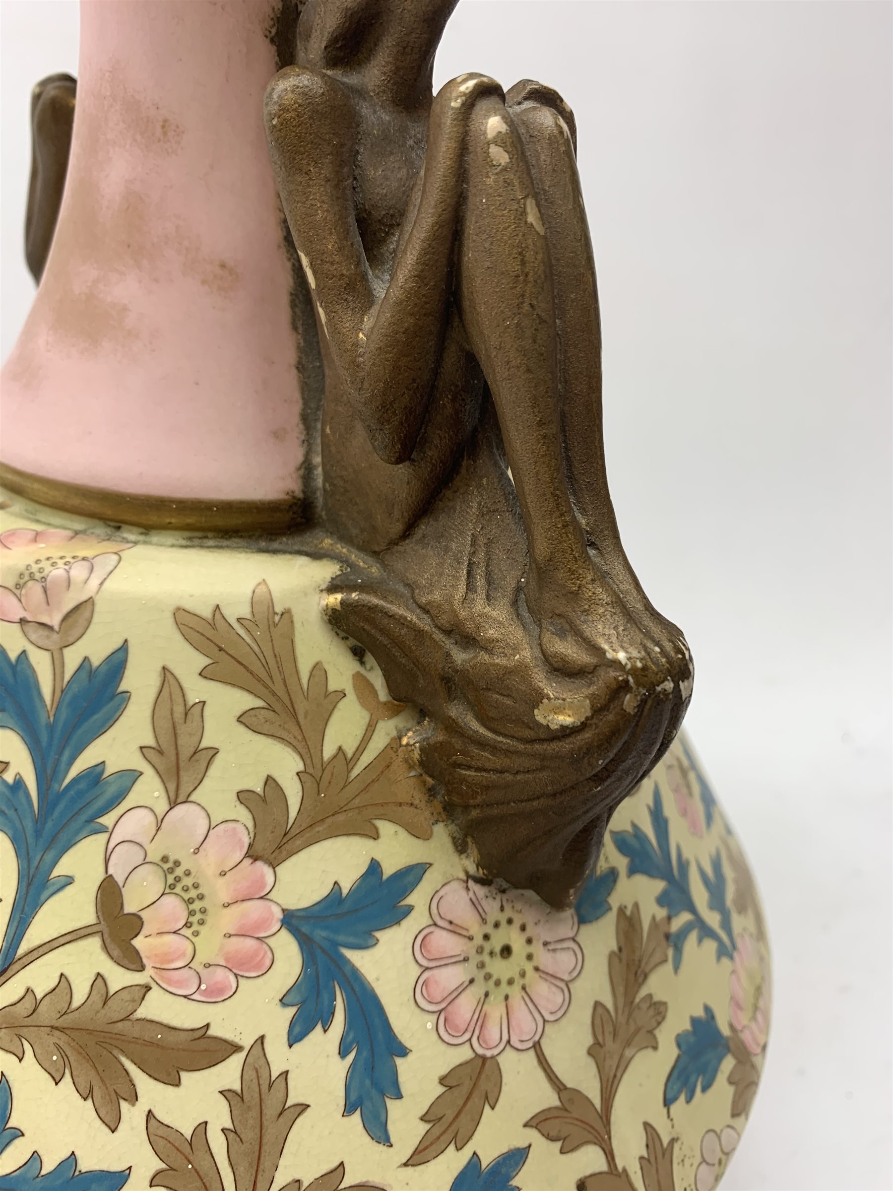 A late 19th century Aesthetic Movement Old Hall vase designed by Christopher Dresser, the flared body decorated with stylised flowering vines, leading to a tapering neck and flared rim with twin figural handles (one s/d), and raised upon a circular footed base, with printed mark beneath, H35cm. 