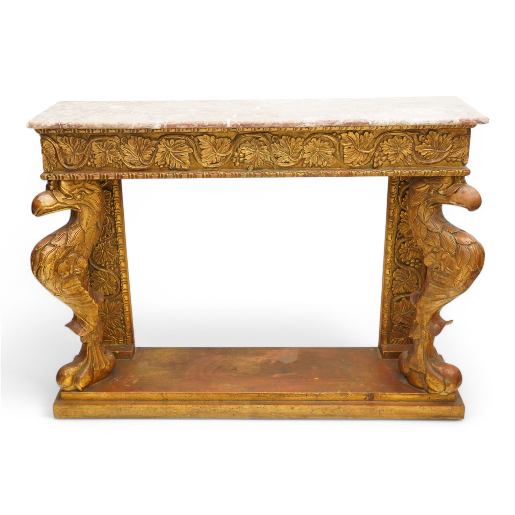 Pair of carved giltwood and composition console or pier tables, rectangular variegated rouge marble top, the frieze decorated with trailing vine and grape bunches, eagle front supports on stepped rectangular base