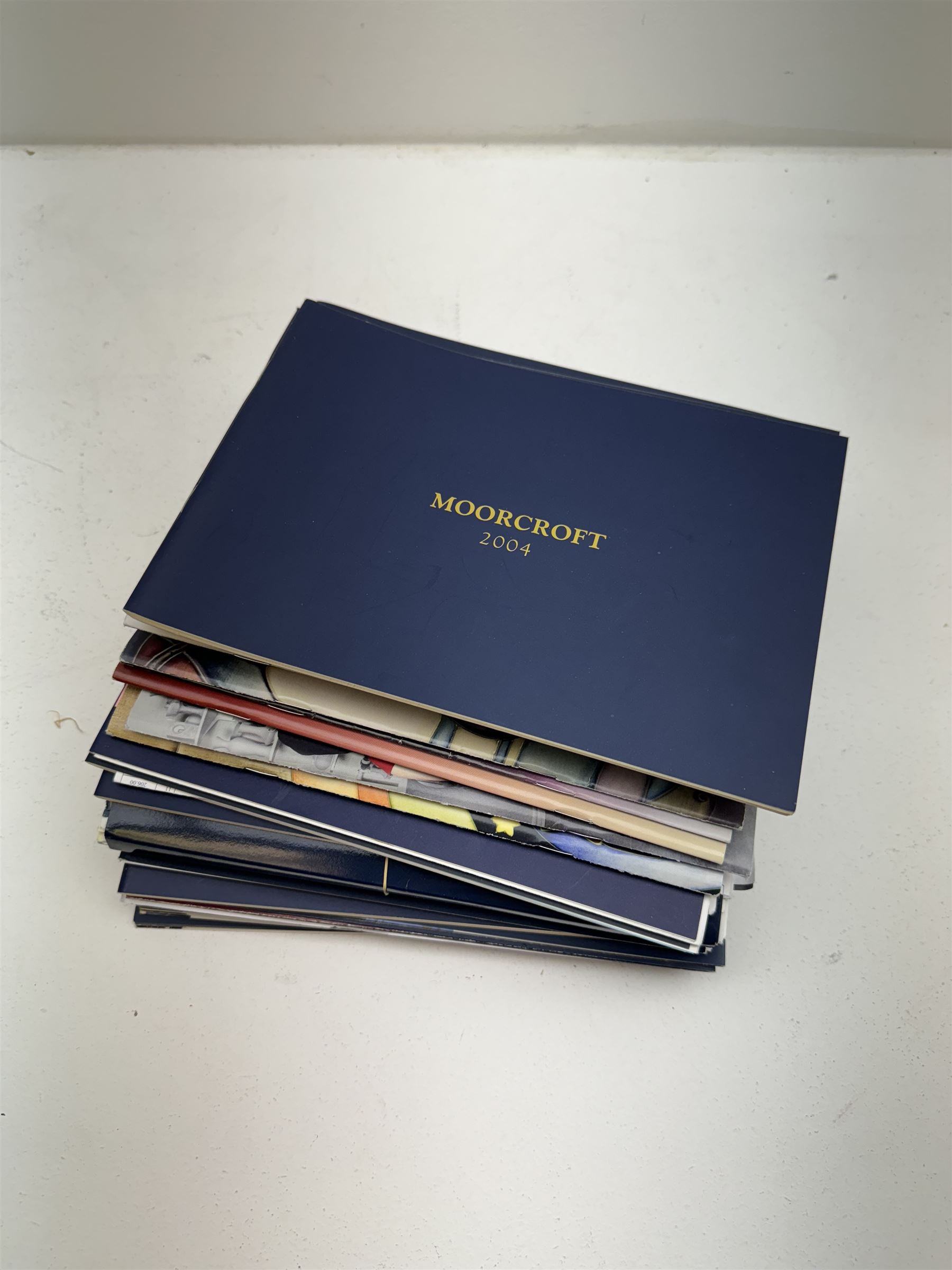 Three Moorcroft reference books, comprising Winds of Change, The Phoenix Years and A New Dawn, together with a collection of Moorcroft magazines 