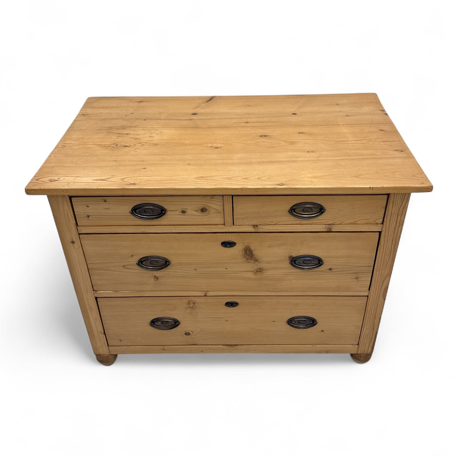 19th century pine chest of drawers, rectangular top over two short and two long drawers with oval pressed brass backplates and drop handles, panelled sides, rounded front edges, on compressed bun feet