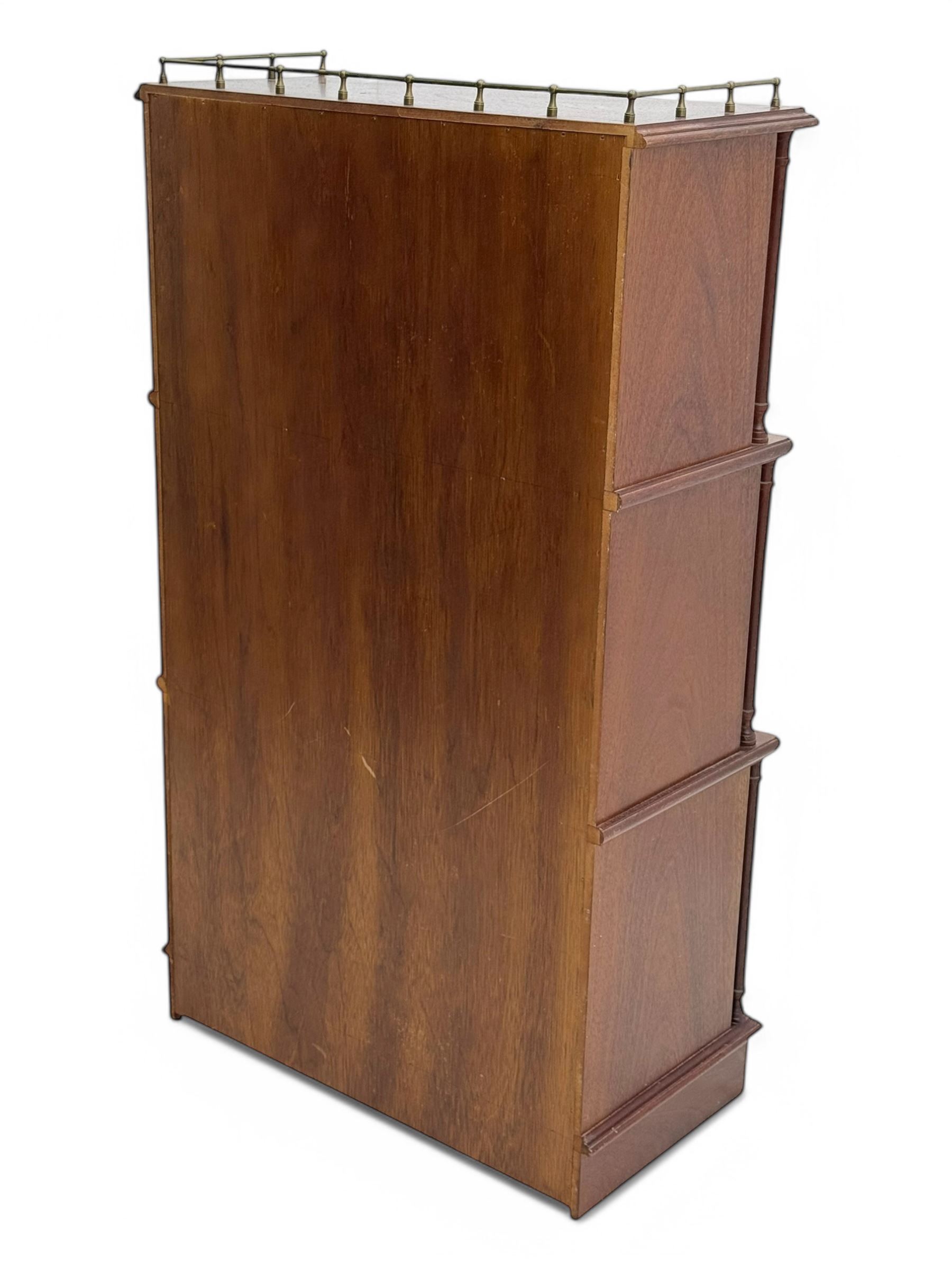 Mid-20th century mahogany open bookshelf, the rectangular top with a brass balustrade gallery, over three shelves each supported by turned column uprights, on shaped apron base