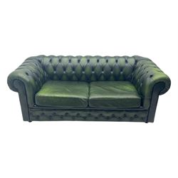 Two seat Chesterfield design sofa bed, upholstered in emerald green leather with deep-buttoned detailing, rolled arms, two loose seat cushions, and pull-out 