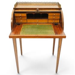 Regency period inlaid mahogany Ladies cylinder writing desk, the rectangular satinwood banded top with raised pierced brass three-quarter gallery, over a cylindrical roll-top enclosing a satinwood fitted interior with pigeonholes, correspondence drawers, ink wells and a sliding hinged writing slope, the base fitted with single frieze drawer, raised on square tapering supports
Provenance: Kirkham Hall