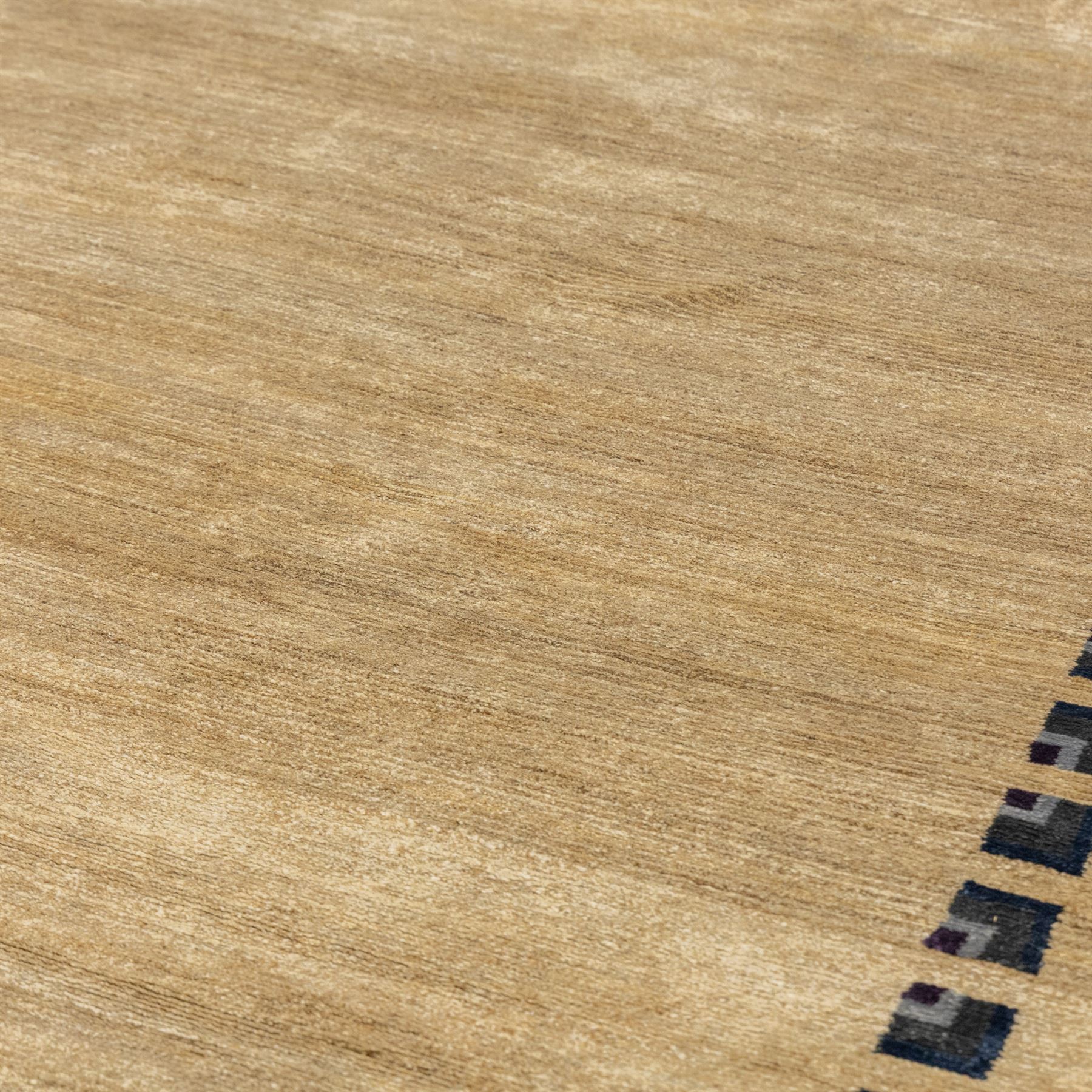 Rugs by Design - ‘Silk Stone’ Nepalese thick pile wool rug, with plain textured camel ground and geometric border detail in blue, grey and dark tones to two sides