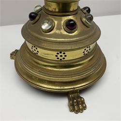 Brass alter cross, decorated with glass cabochons, upon a acicular stepped base and three claw feet, H73cm 