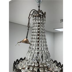 An early 20th century waterfall chandelier, the brassed mounts hung with rectangular, teardrop and button cut drops, overall approximately H70cm.