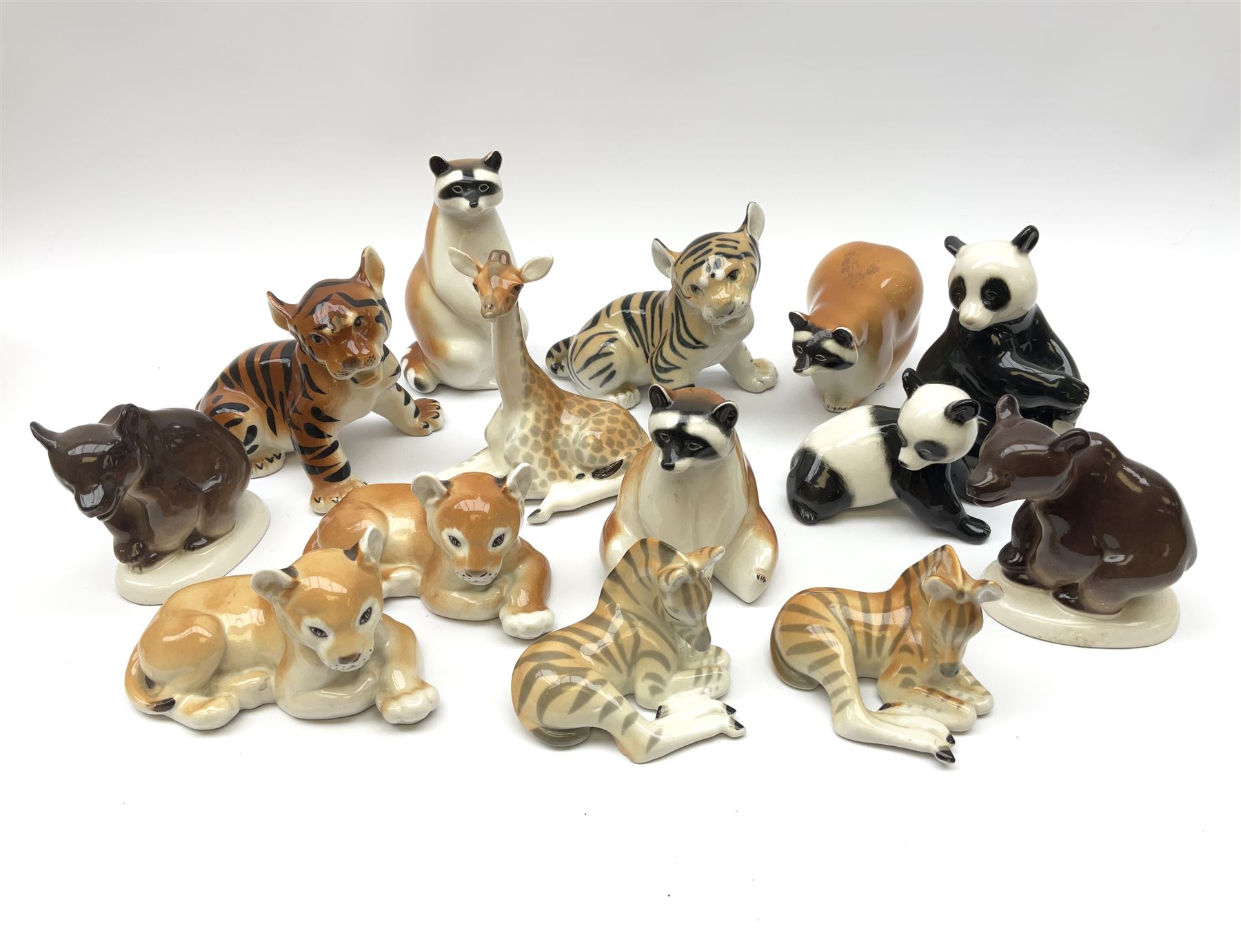 A collection of Russian animal figures, largely comprising Lomonosov examples, to include examples modelled as tigers, zebra, pandas, brown bears, giraffe, and racoons. 