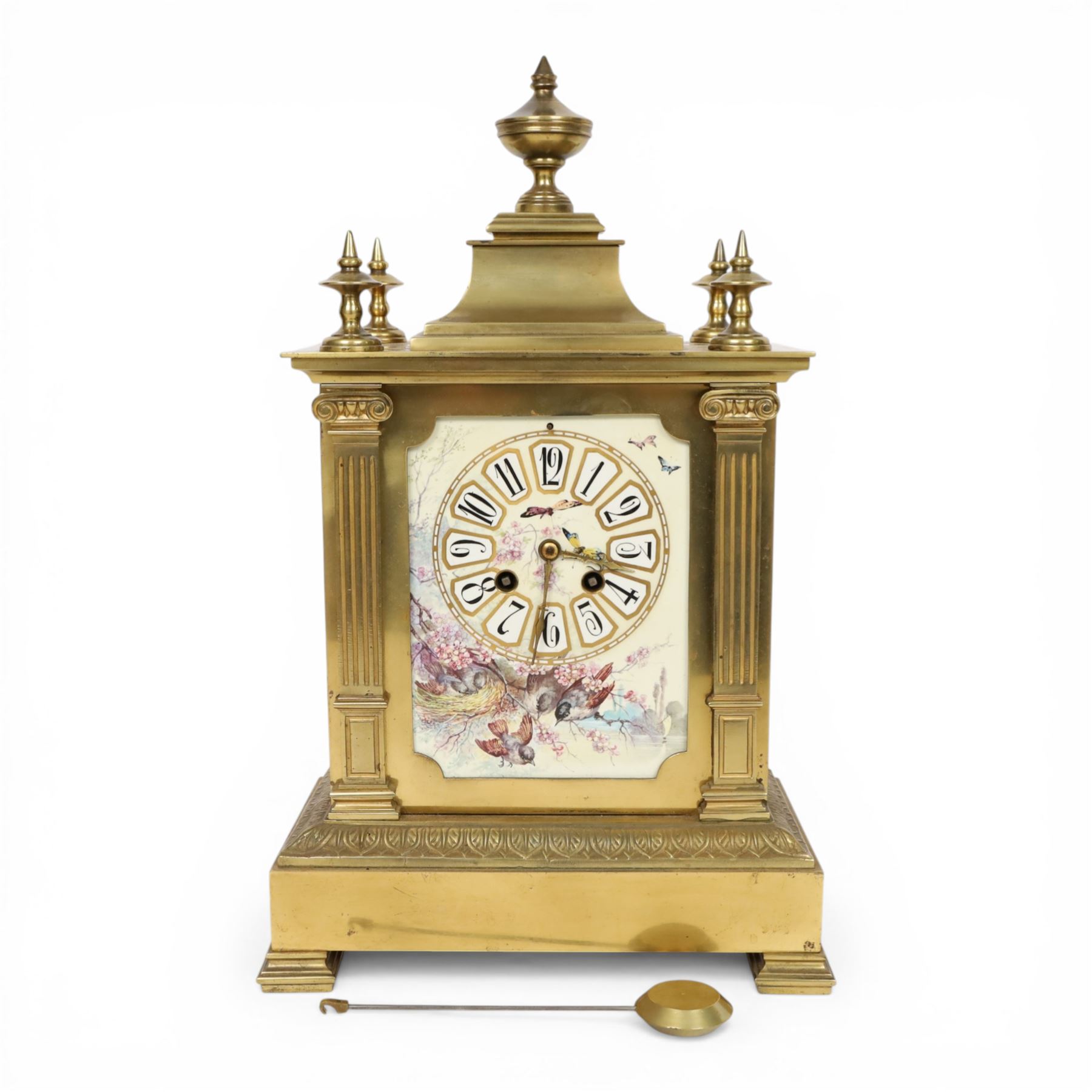 French gilt-bronze and porcelain mantel clock, architectural case surmounted by a stepped pediment with central urn finial and four subsidiary finials above two fluted Corinthian-style pilasters, the entire front inset with shaped porcelain panel incorporating a circular dial and numerals decorated with birds among flowering branches and two winding apertures and pierced brass hands, above a leaf and scroll cast frieze, raised on bracket feet, with an eight-day movement stamped 'AD MOUGIN Deux Medailles' striking the hours and half-hours on a coiled gong, with pendulum, circa 1900