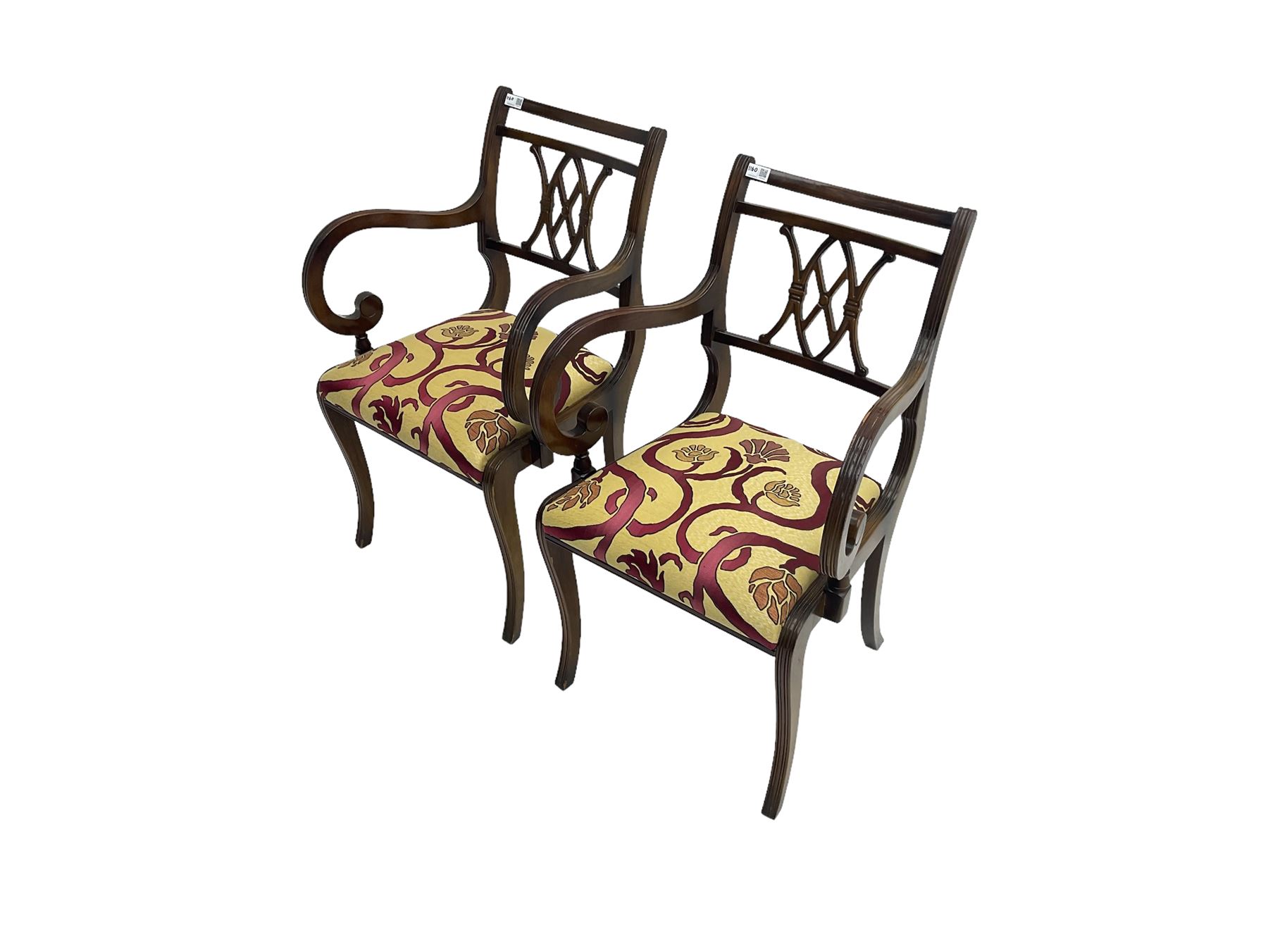 Regency design mahogany twin pedestal dining table, rectangular top with reeded edge, acanthus carved turned column terminating in reeded tripod base with hairy paw feet and castors (W172cm D92cm H75cm) and set eight (6+2) Regency design mahogany dining chairs, pierced back with scroll design, seat upholstered in patterned laurel green fabric, raised on reeded sabre supports (W48cm H88cm)