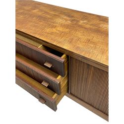 Mid-20th century teak sideboard, three central drawers flanked by tambour roll doors, the righthand side fitted with slides, on tapering feet