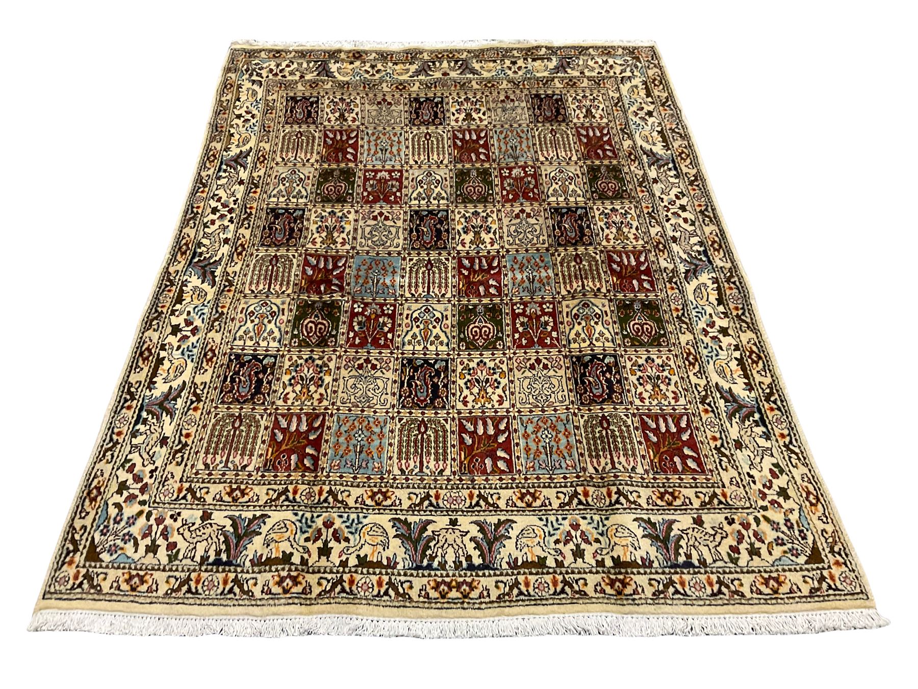 Persian Heriz design rug, ivory ground with rectangular panels each depicting garden scenes of tree of life, plants and Boteh motifs, the guarded border decorated with wildlife and bird scenes