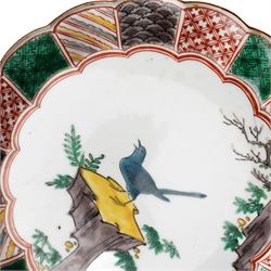 Pair of Japanese Edo period Ko Kutani dishes, decorated in green, yellow, blue iron-red, and aubergine enamels, the centres painted with a singing bird perched on a rock among foliage, within a border of alternating geometric designs and a chocolate-brown rim, the reverse with underglaze blue foliage, Fuku mark, D20.8cm (2) A matching pair of dishes is held in the collection of the Cleveland Museum of Art (see accession no. 1964.262)