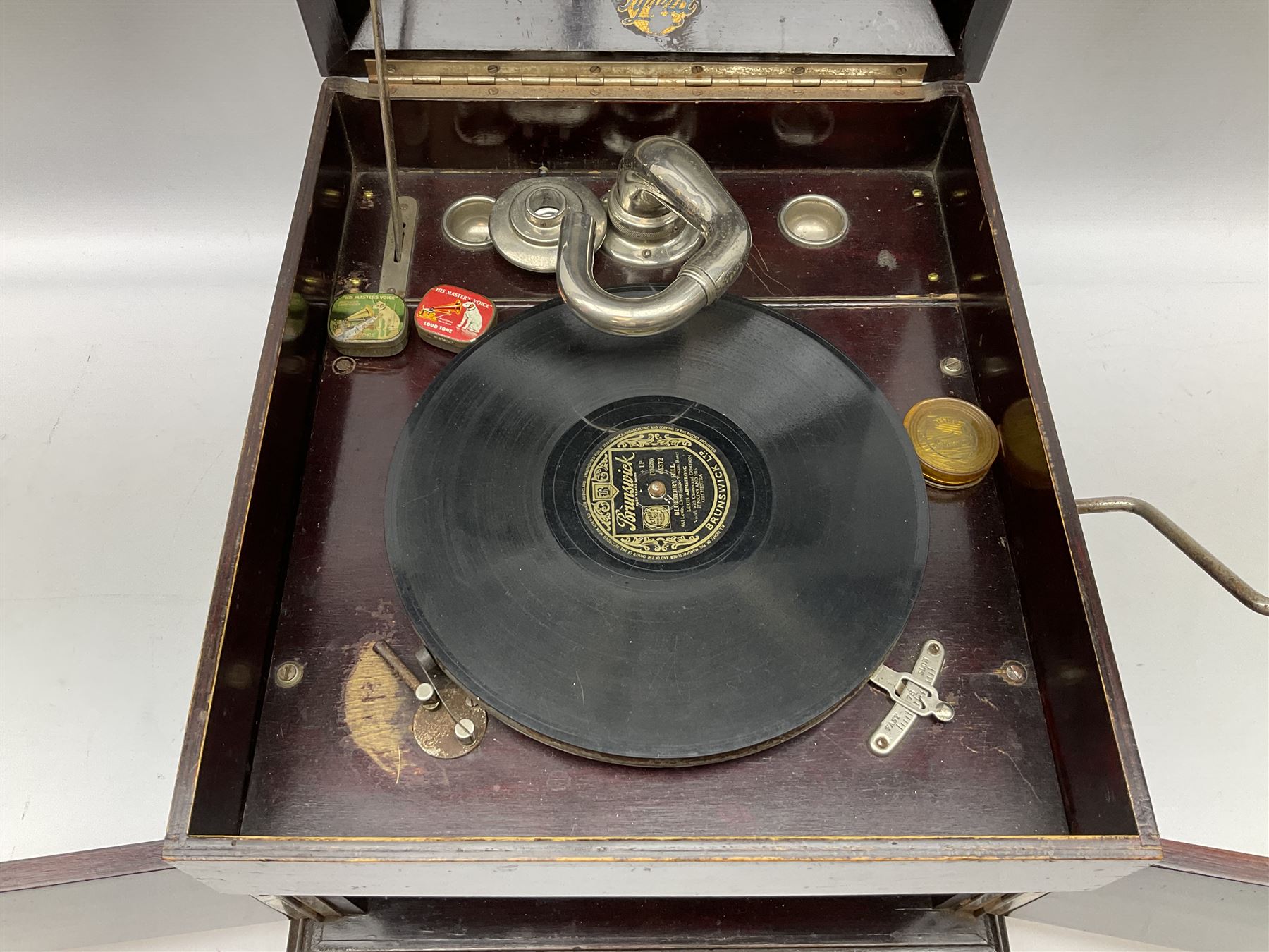 Early 20th century wind up gramophone set in a wooden case with twin door sound hole to the front and tins of 'His Masters Voice' needles