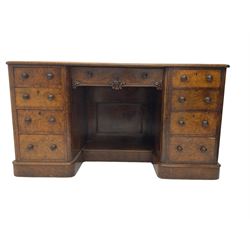 Victorian figured walnut kneehole desk, moulded rectangular top with inset leather writing surface, fitted with nine drawers, the central frieze drawer with carved curled foliage mount, on moulded plinth base,